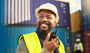 worker holding a walkie talkie smiling