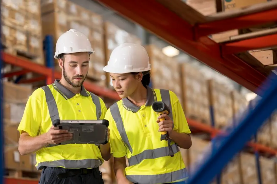Warehouse workers using tablet and scanner